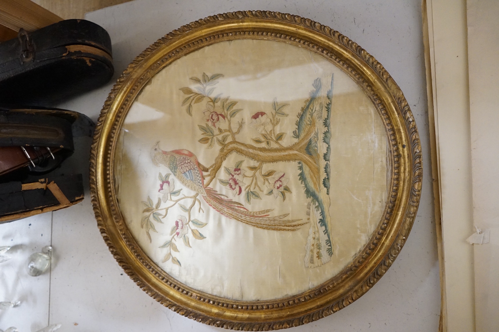 Two 18th century oval silkwork panels, one depicting flowers, monogrammed AM and dated 1787, together with a 19th century watercolour portrait of a lady, largest 42cm high
